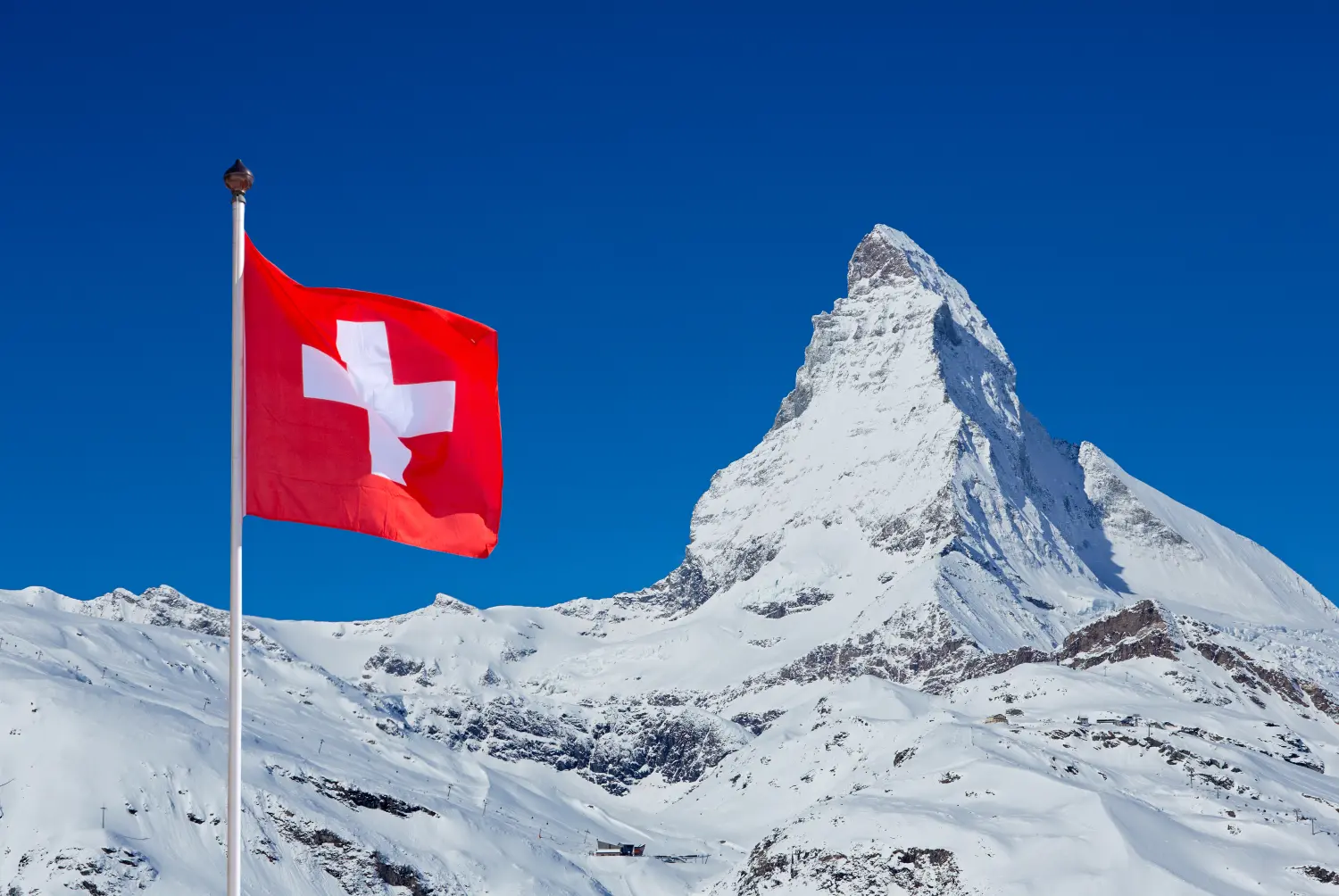 Famous Matterhorn with flag of switzerland on blue sky 